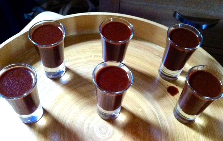 Six glasses of chocolate rum shots on a tray.