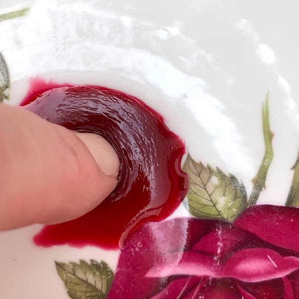The Wrinkle Test. Finger pushing a blob of jam to see if it wrinkles and is therefore set.