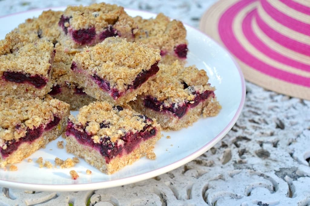 A cake stand piled with blackberry crumble bars.