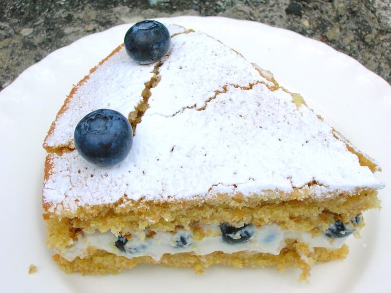 A slice of blueberry white chocolate cake with rose labneh filling.