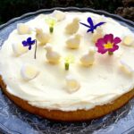 Easter lemon & apple curd cake decorated with edible flowers and white chocolate chicks.