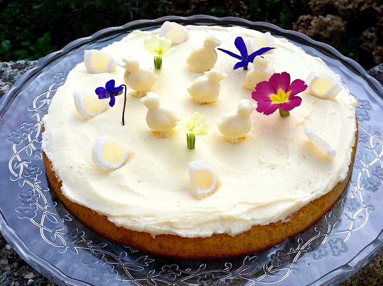 Easter lemon & apple curd cake decorated with edible flowers and white chocolate chicks.