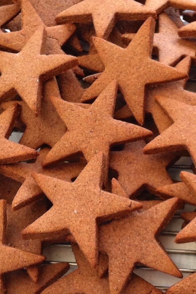 Honey and cinnamon Christmas star biscuits cooling on a rack.