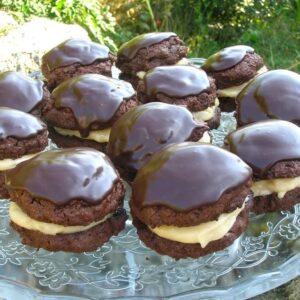 A stand of chocolate whoopie pies with a marshmallow cream filling and chocolate icing.