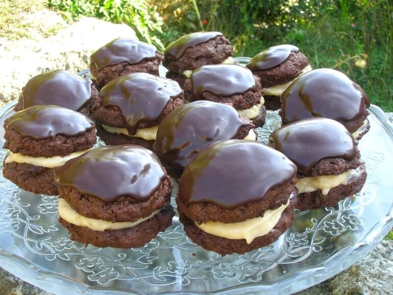 A stand of chocolate whoopie pies with a marshmallow cream filling and chocolate icing.