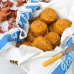 Basket of healthy vegan pumpkin scones surrounded by autumn leaves.