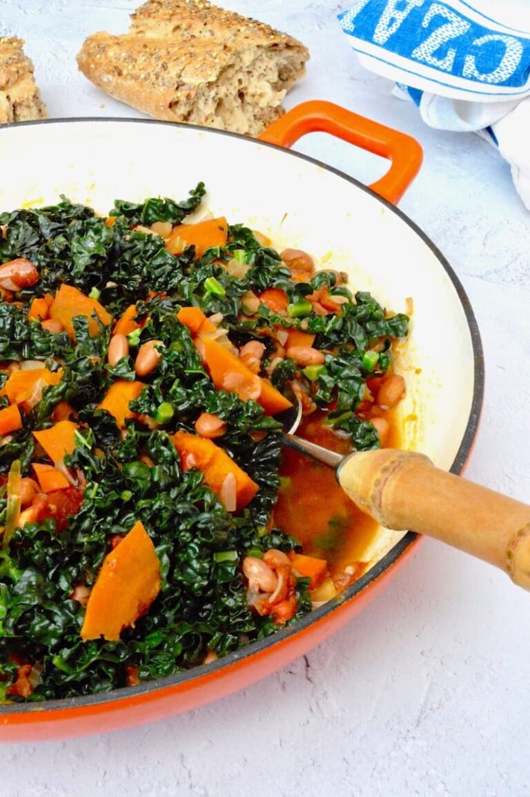 A dish of vegan pumpkin stew with borlotti beans, tomatoes, cavolo nero and pot barley.