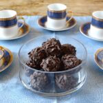 Glass bowl of whisky truffles with blue and gold stripe Turkish coffee cups.