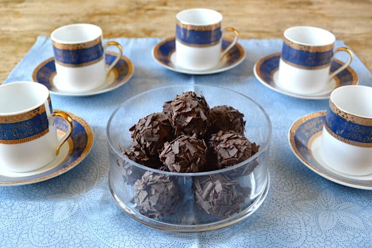 Glass bowl of whisky truffles with blue and gold stripe Turkish coffee cups.