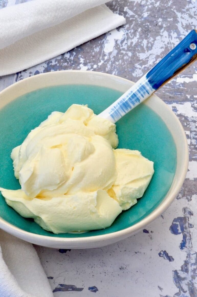 A turquoise bowl of homemade crème fraîche with blue spoon.
