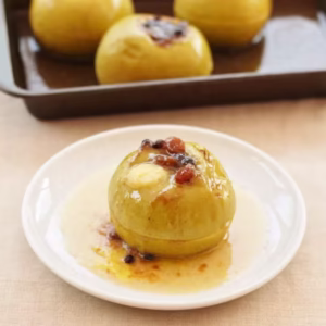 Baked apple with mincemeat with further tray of apples behind.