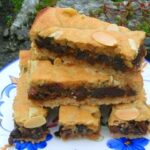 A stack of almond chocolate mincemeat slices on a blue patterned plate.