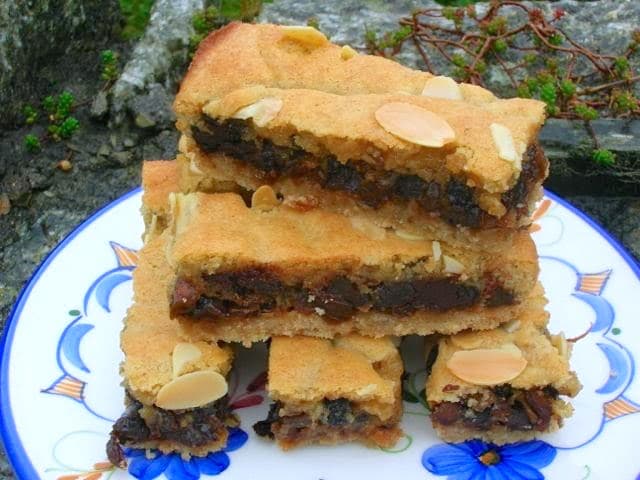 A stack of almond chocolate mincemeat slices on a blue patterned plate.