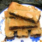 Stack of homemade almond mincemeat slices on blue patterned plate.