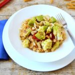 White bowl of lemon and garlic romanesco pasta with fork.