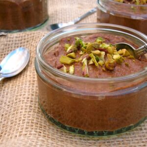 Chocolate Chia Pudding with chopped pistachios on top and an apostle spoon.