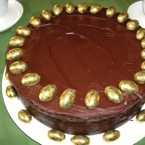 A chocolate Guinness cake decorated with gold foil covered mini Easter eggs.