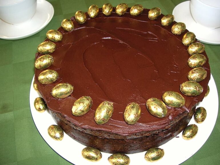 A chocolate Guinness cake decorated with gold foil covered mini Easter eggs.