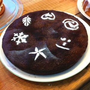 Chocolate hazelnut torte decorated with icing sugar patterns.