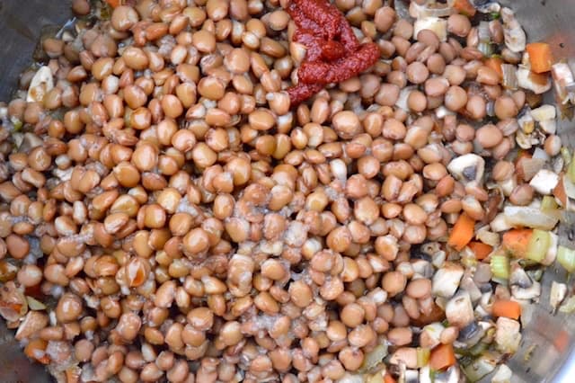 Cooked lentils added to pan of mushrooms and soffritto.