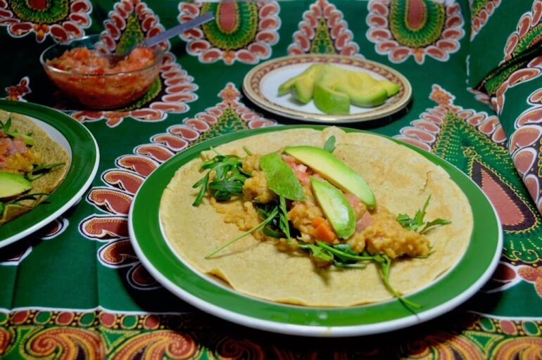 Pancake wraps with spiced lentils. Showing an open pancake on a plate with the filling in the middle prior to folding.