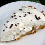 A slice of banoffee pie on a white plate.