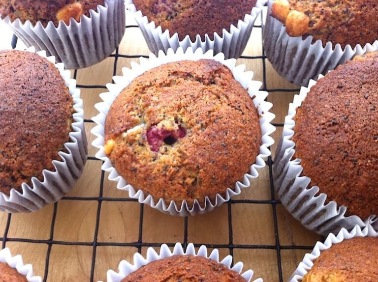 Raspberry and poppy seed muffins cooling on a wire rack.