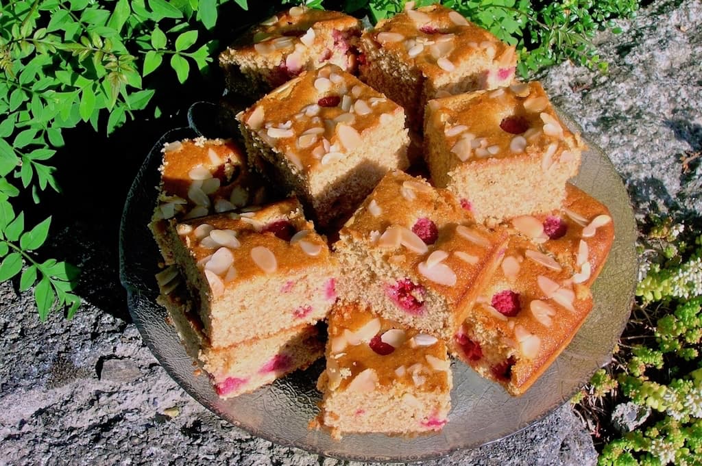 Raspberry, Rose and White Chocolate Cake - a traybake cut into 16 squares.