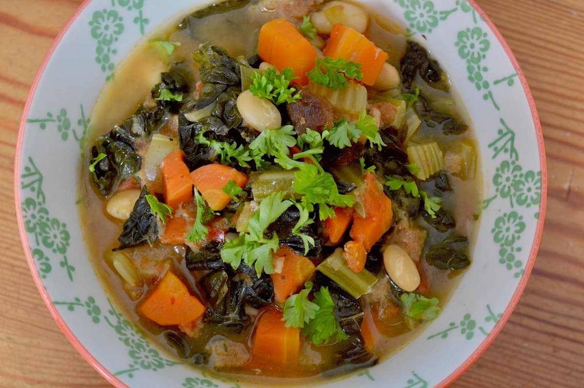 A close up of the top of a bowl of veg-filled Ribollita: a vegan Tuscan soup.
