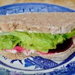 Vegan 'Cream Cheese', Spiced Pickled Beetroot & Lettuce Sandwich on a blue plate.