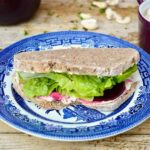 Vegan 'cream cheese', pickled beetroot & lettuce sandwich on blue plate.