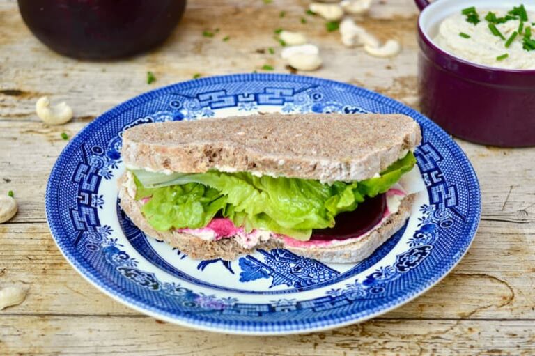 Vegan 'cream cheese', pickled beetroot & lettuce sandwich on blue plate.