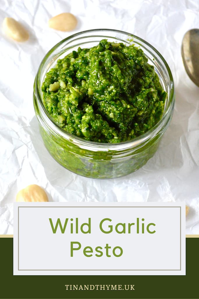 An open glass jar of wild garlic pesto with almonds scattered around. Text box reads "Wild Garlic Pesto".