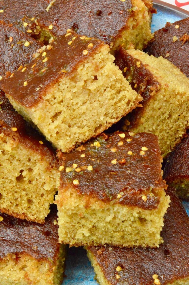 Squares of pineapple juice cake piled on top of each other.