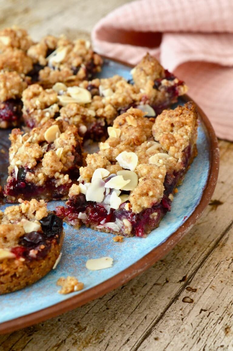 Close up of a partial plate of blackcurrant almond bars.