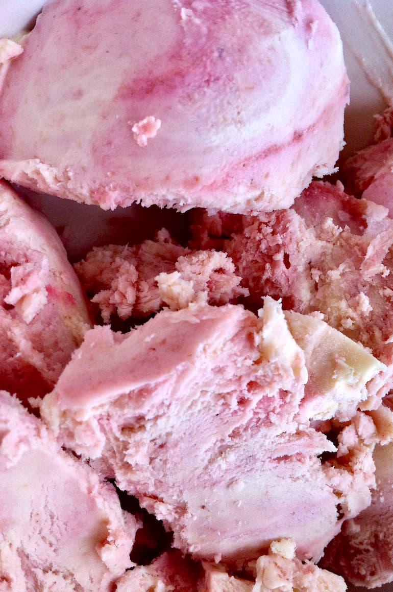 Close up of homemade redcurrant ripple ice cream in a bowl.