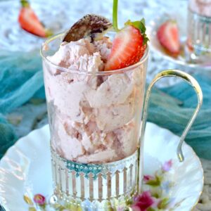 A glass of roasted strawberry ice cream with strawberry on top.