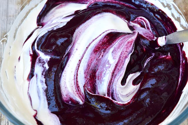 A bowl of rippled whipped cream and berry purée.