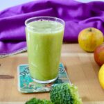 A glass of green goddess smoothie made with apples, broccoli and ginger.