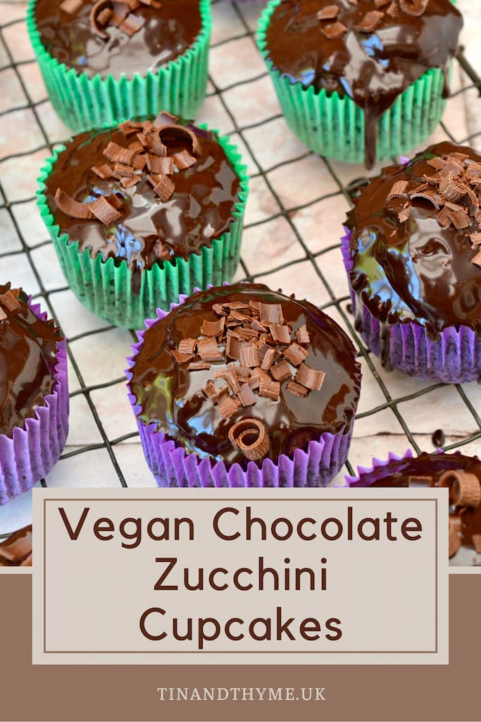 Glossy chocolate covered vegan courgette cupcakes in green and purple paper cases.
