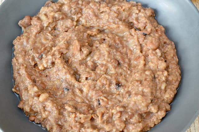 A bowl of partially mashed fava beans.