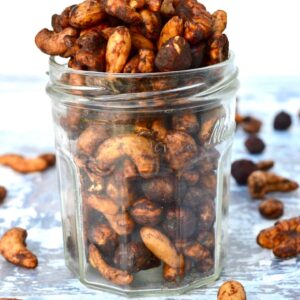 A jar with healthy roasted nuts spilling out of the top.