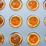 A baking tin filled with a variety of easy jam tarts just out of the oven.