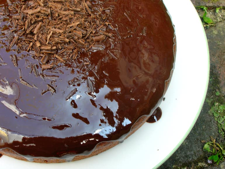 Partial view of a glazed spicy dark vegan chocolate cake.