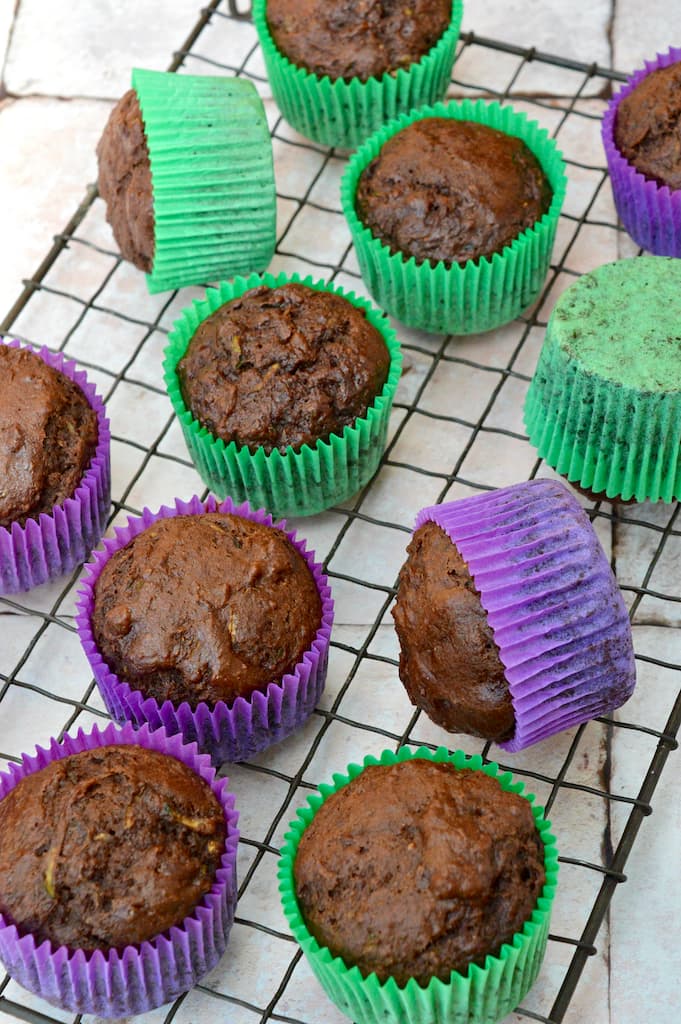 Unglazed vegan chocolate courgette muffins in green and purple cases.