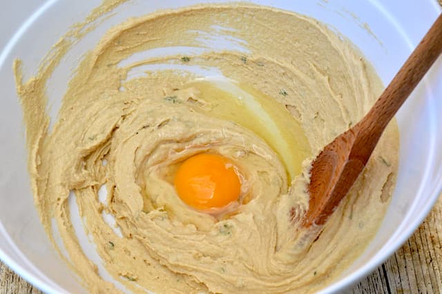 Creamed butter and sugar in a mixing bowl with an egg dropped into the middle.