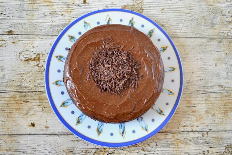 A homemade vegan chocolate banana cashew cake with grated chocolate on top..