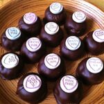 A bamboo platter of hazelnut chocolate cake truffles topped with love hearts.