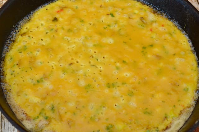 Leftover mashed potato omelette cooking in an iron skillet.