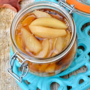 An open clip-top jar of pears poached in dessert wine.